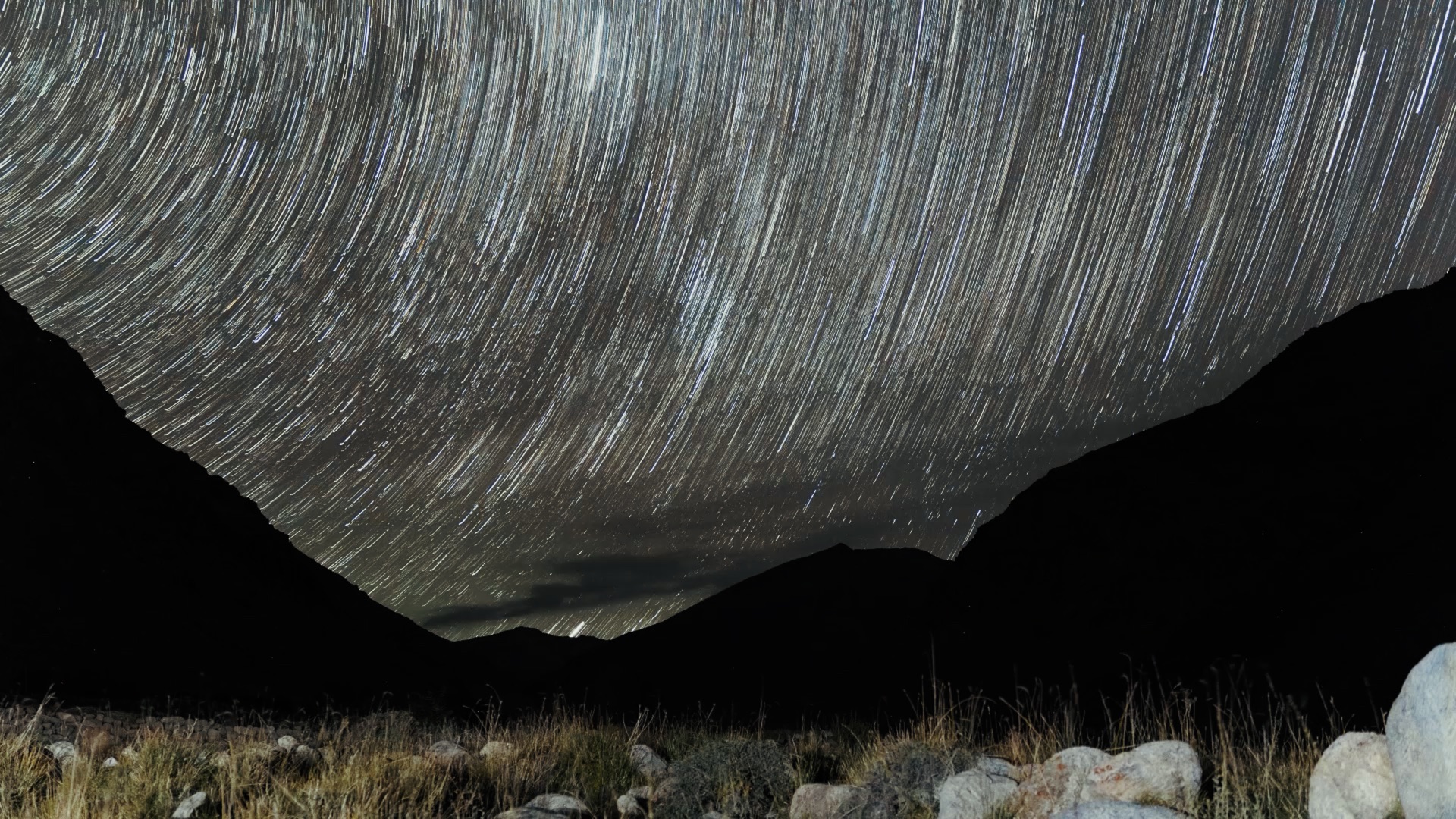 Long-exposure star trails arcing over Ladakhi mountain ridgeline at night